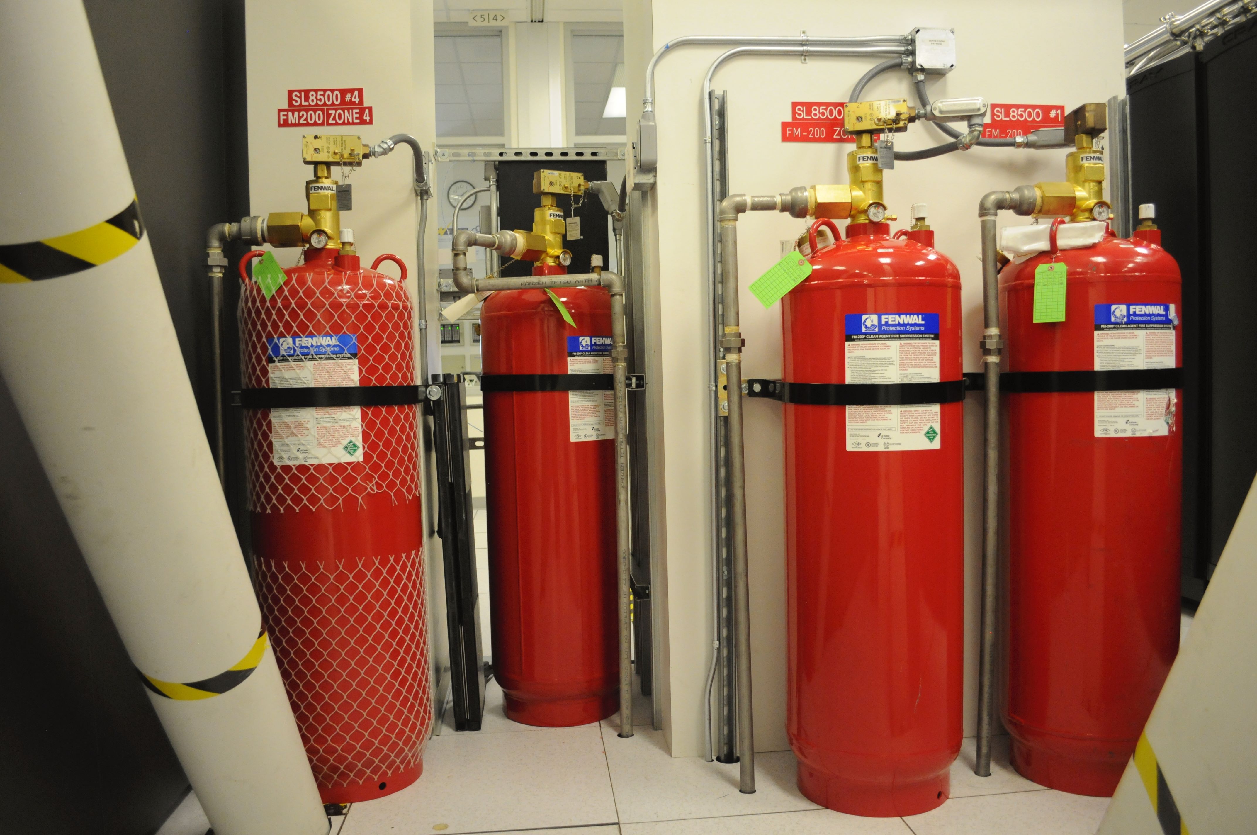 Fenwal FM-200 clean-agent fire suppression cylinders with valves and zone labels